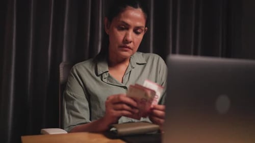 A woman is stressed from life problems. Not having enough money, working woman counting money