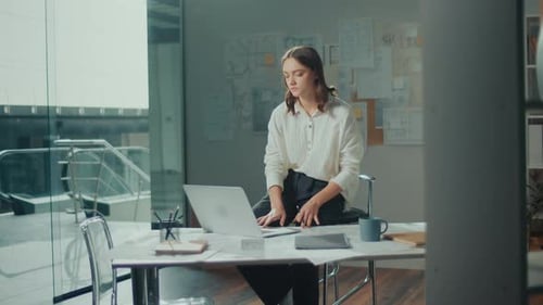Young Female Architect Is Hard at Work in Her Office on Blueprints and Projects