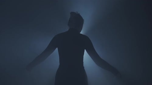 Female Model Against Bright Backlight on Black Smoky Background in Studio Female Silhouette Moving