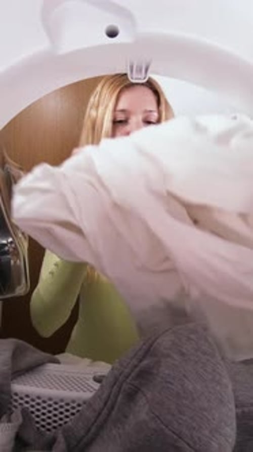 Young Woman Taking Clothes Out of Washing Machine
