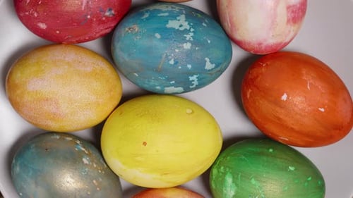 A top view of variously colored Easter eggs, including blue, red, yellow, and green, spread out on a