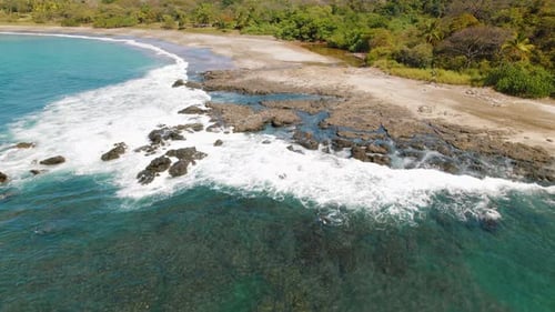 Aerial of tropical beach with turquoise water and sandy shoreline in Costa Rica