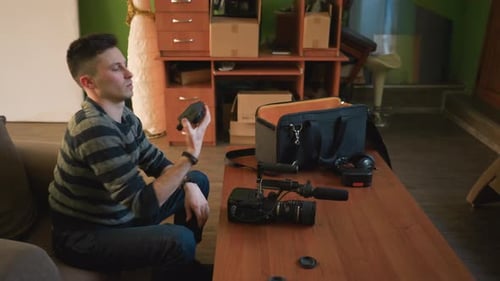 Young Man Assembling Video Camera Equipment on Table