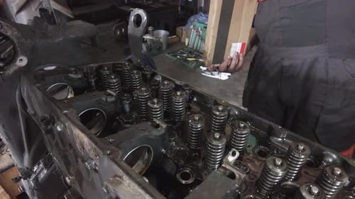 Mechanics Adding Metal Parts to Large Engine
