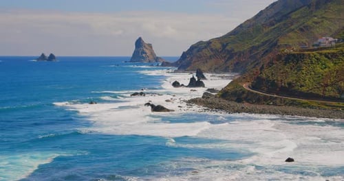 Atlantic ocean coast. Highway near to beautiful sea. Green rocks. Waves splashing, crash on rocky sh