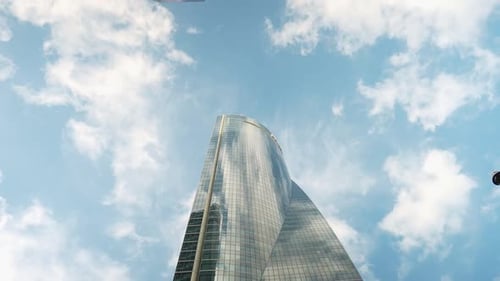 Timelapse White Clouds Passing on Blue Sky Reflecting in Glass Urban Skyscraper Low Angle View of