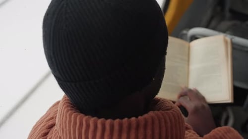 Person with Book on Vehicle Individual Studying Paperback During Bus Ride Commuter Reading and