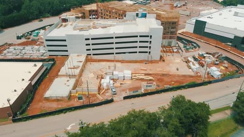 A slow reveal of an active construction site, including workers and large pieces of equipment