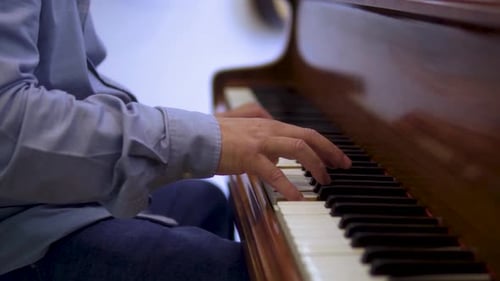 talented elderly piano artist musician is playing classical music wearing blue shirt and jeans close