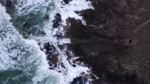 Abstract Top Down Foamy Ocean Waves Crashes Rock