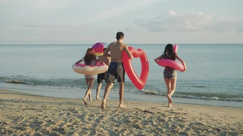 Slow motion: Close up group friends running enjoy life playing and freedom beach at sunset