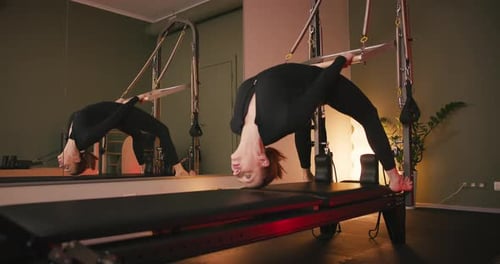 Woman Exercising on Pilates Machine in Studio