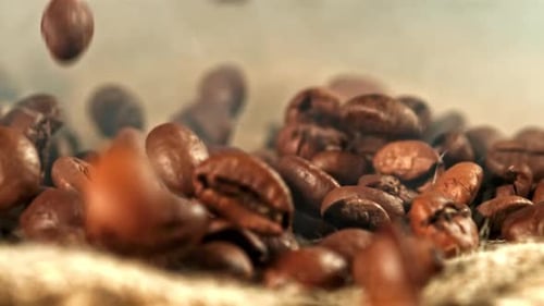 Roasted coffee beans falling in slow motion close-up