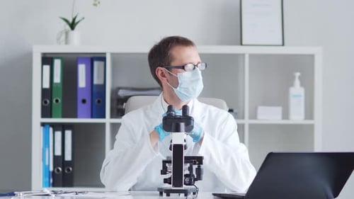 Medical Professional Examines Microscope in Lab