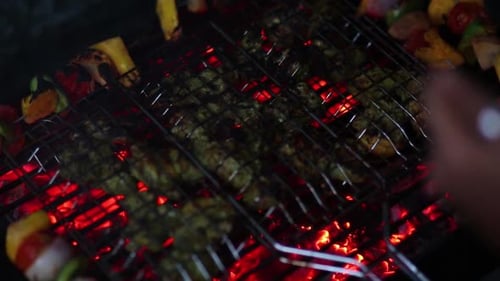 Close up of barbecue grill with veggie skewers. High angle, handheld