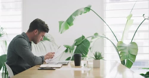 4K-Videomaterial eines jungen Geschäftsmannes, der in einem Büro Papierkram durchgeht