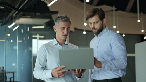Two Business Professionals Discussing Work At The Office