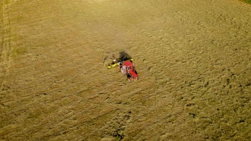 Agricultor em trator com Hay Tedder aerando e acelerando a secagem da grama em campo agrícola para
