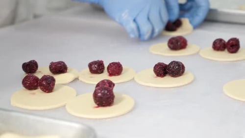 60x. Elaboración de albóndigas moldeadas con cerezas. Trabajo en equipo en la cocina. Cocina casera.