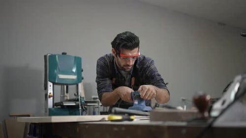 Carpenter is working at workshop.