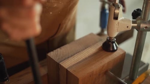 Close-Up Shot of a Carpenter Using a Drill to Work on a Piece of Wood