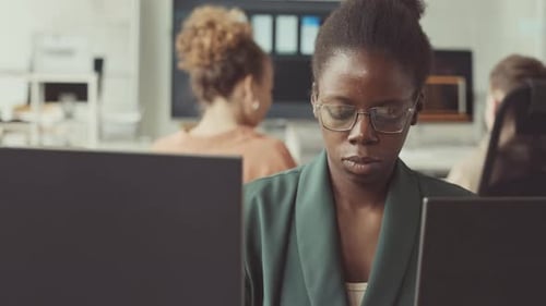Afroamerikanische Programmiererin arbeitet im Büro am PC