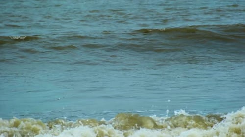 Nahaufnahme von Meereswellen, die am Strand plätschern - Türkisblaue Meereswellen plätschern am Strand.