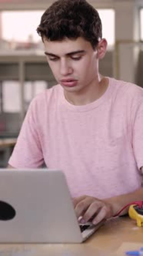 Young Student Boy Working on Laptop at High School