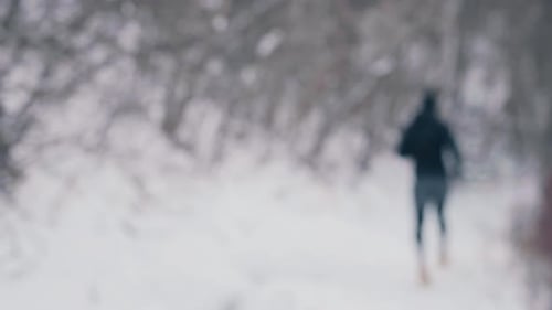 People Running in Snow During a Winter Day