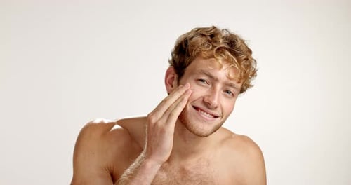 Face, cream and man with cosmetics, skincare and dermatology on studio background