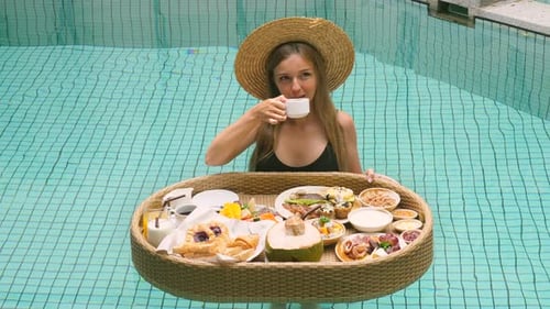 Traveler Drinking Coffee From Floating Breakfast in Swimming Pool