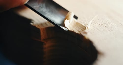 Macro au ralenti d'un maître artisan luthier effectuant un travail minutieux et détaillé sur un violon en bois dans un atelier