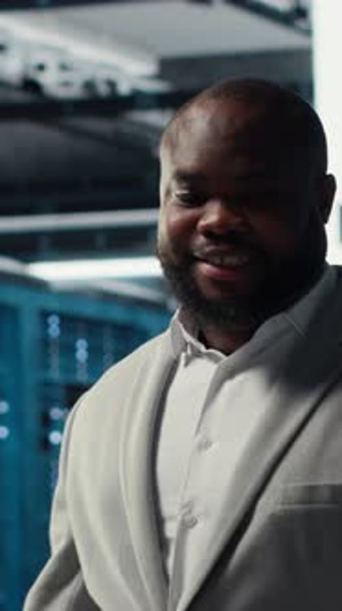 Vertical Video Smiling Employee Walking in High Tech Data Center