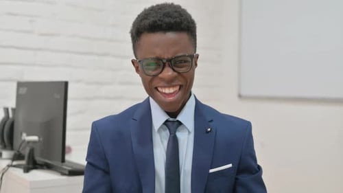 Excited Young Adult Man Celebrating Success in Office