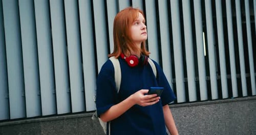 Portrait of Happy Red Haired Young Woman Student with Backpack and Phone Outdoors College Student in