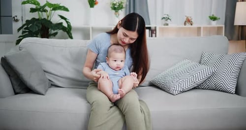 Loving Mother Interacting with Infant on Couch