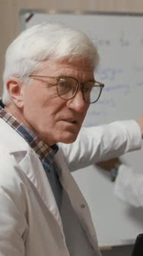 Senior Male Teacher Educating Medical Students in Lecture Room at College