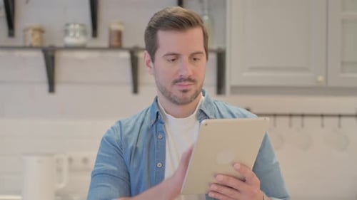 Man Swiping on Tablet in Modern Kitchen