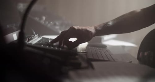 Faceless Guitarist Recording Music in Dark Studio