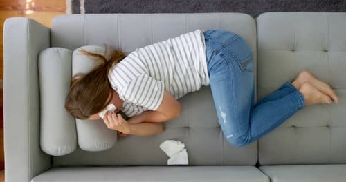 Woman Lying on Couch with a Tissue