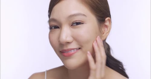 Young Woman Touching Her Face and Smiling