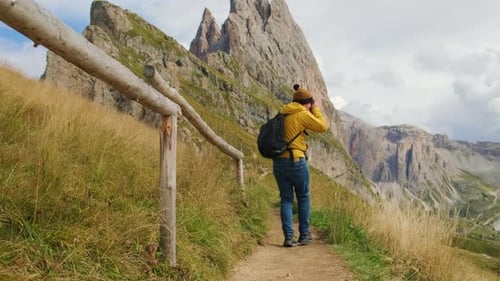 Un touriste de sexe masculin prend des photos de la montagne Seceda située dans les Alpes italiennes