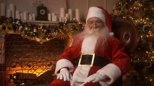 Santa Claus Sitting by Christmas Tree in Decorated Home