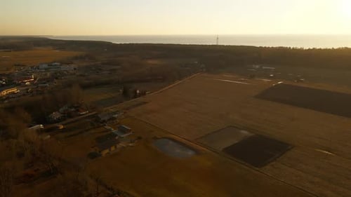 Sunset Aerial View of a Field with Water in the Background