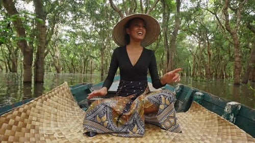 Woman in Boat Paddles Through Flooded Tropical Forest
