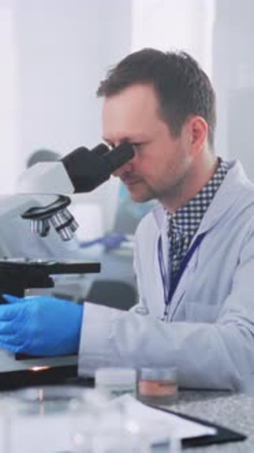 Male Scientist Using Microscope in Medical Lab