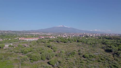 Aerial orbit over the village under the Etna Volcano in summer