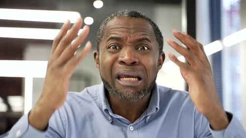 Webcam view. Angry dissatisfied african american businessman arguing talking on video call looking