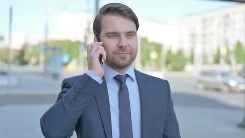 Businessman in Suit Talking on Phone Outdoors