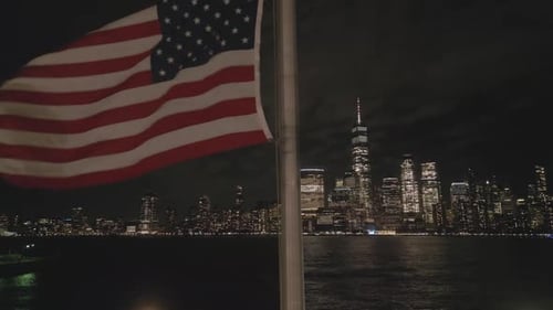 City Skyline Shines Behind Waving American Flag